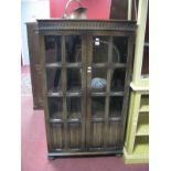 An Oak Display Cabinet, with knulled decoration over twin six glazed panel and linen fold doors,