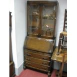 A 1940's Oak Bureau Bookcase, with lead glazed upper doors, over fall front, three drawers, ball and