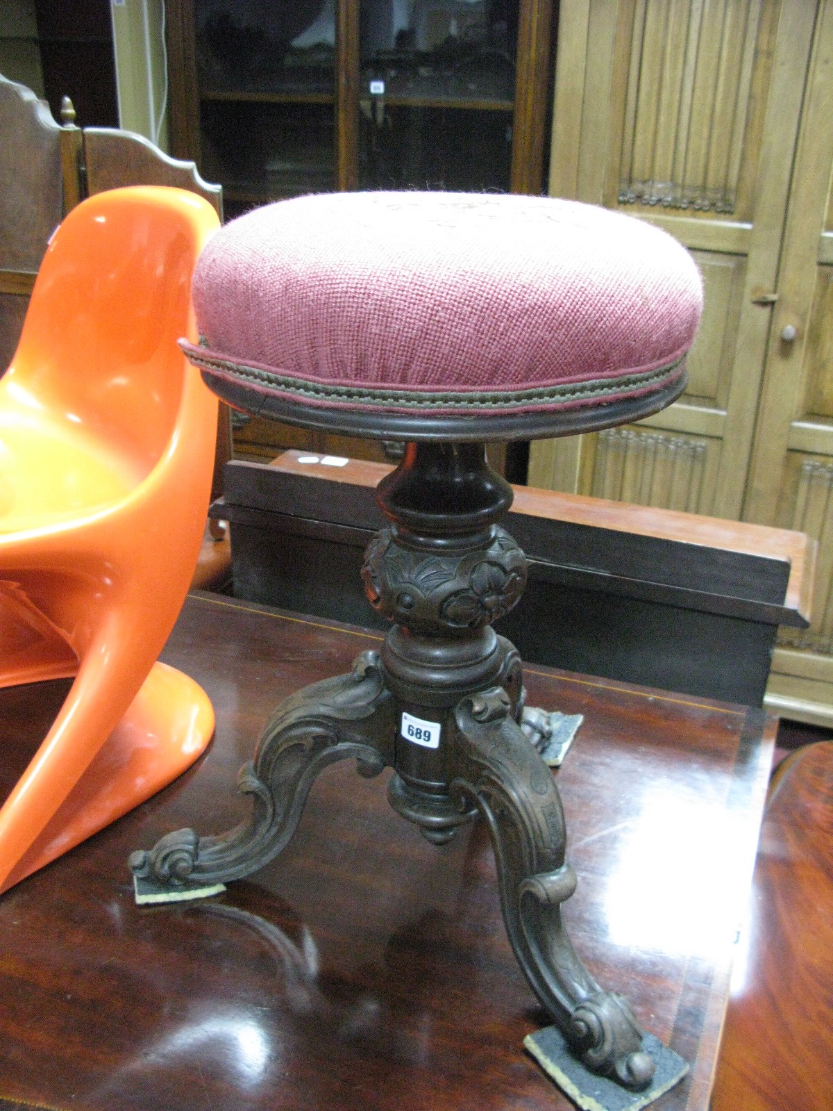 A XIX Century Rosewood Revolving Piano Stool, with upholstered top, turned pedestal, on cabriole