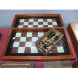 A Victorian Cased Folding Glass Chess Board, together with chess pieces.