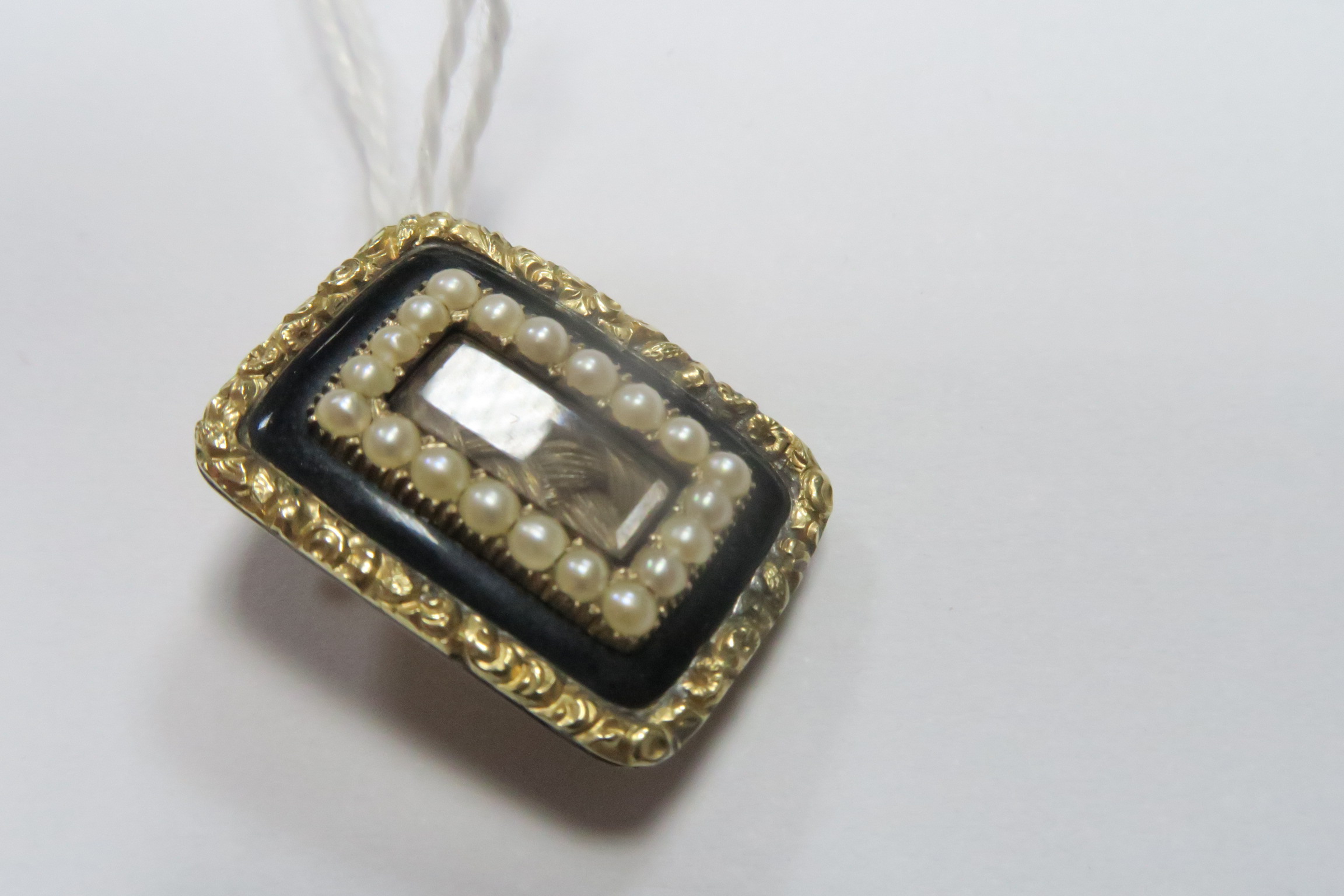 A XIX Century Mourning Brooch, of rectangular form with central glazed hairwork panel, inscribed