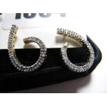 A Pair of Modern 9ct Gold Diamond Set Earrings, of swirl design, uniform claw set throughout.
