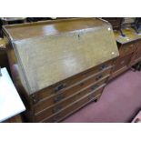 An Early XIX Century Oak Bureau, with a threequarter gallery, fall front, fitted interior, four long