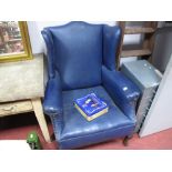 An Early XX Century Wing Chair, upholstered in a blue leatherette, on cabriole legs.