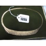 A 9ct Gold Necklace, of geometric textured fringe design, in original fitted case.