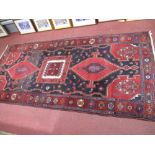 Persian Wool Rug, with square centre motif flanked by hexagonal examples on a red ground, 240 x