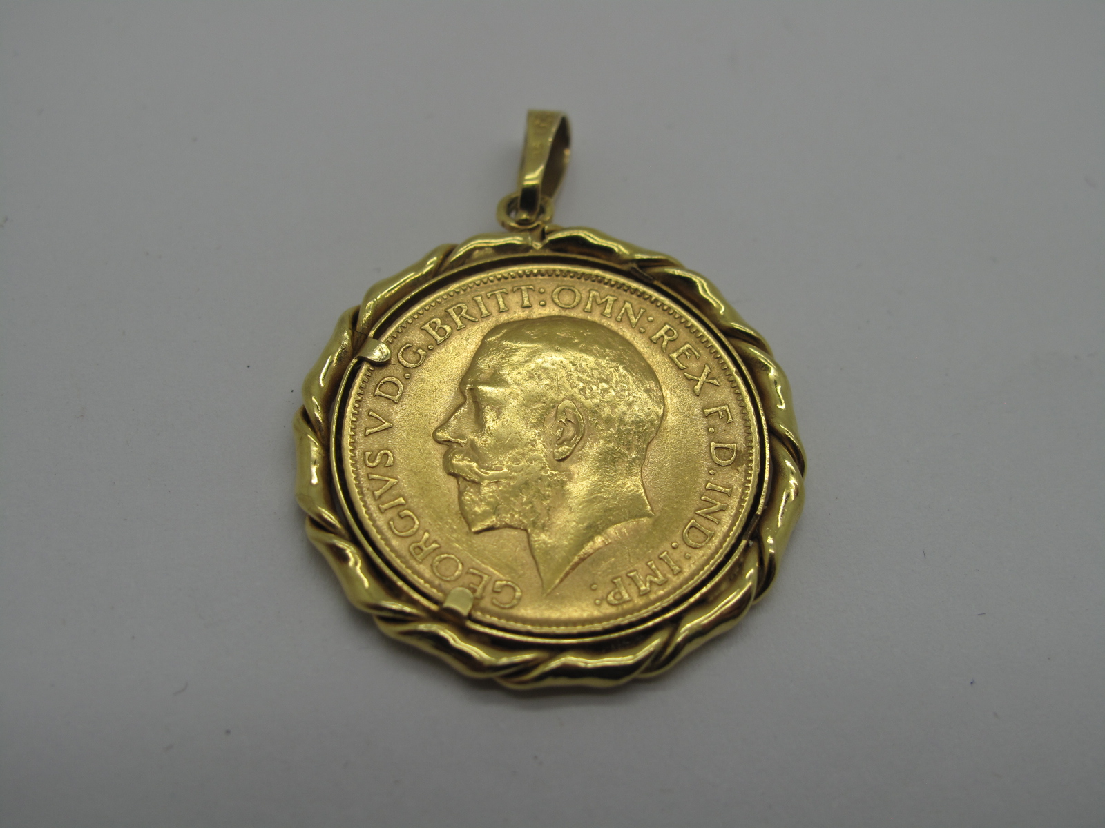 A Sovereign, 1911, GF. Hard mounted in a pendant.