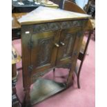 A Mid XX Century Oak Floor Standing Corner Cabinet, with carved stylised leaf panels to doors.