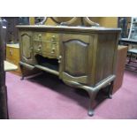 An Early XX Century Oak Sideboard Base, with two central drawers, flanking cupboards, on cabriole