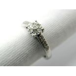 A Modern Diamond Set Ring, illusion set, between inset shoulders, stamped "9K" "0.10". *Morris