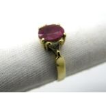 A Ruby Ring, oval claw set to the centre, between triangular inset shoulders, stamped "14K".