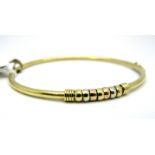 A Modern Bangle, of plain design with three colour detail to the front, hinged to snap clasp,