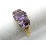 A Modern 9ct Gold Amethyst Three Stone Ring, graduated oval claw set, with inset highlights.