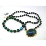 A Modern Mottled Hardstone Bead Necklace, clasp stamped "585", suspending collet set oval panel,