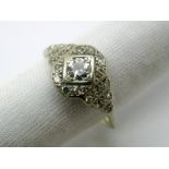 An Art Deco Diamond Set Ring, set to the centre with an old brilliant cut stone, within diamond