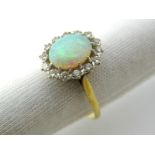 An 18ct Gold Opal and Diamond Cluster Ring, oval cabochon claw set to the centre, within border of