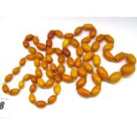 A Long Graduated Single Strand Amber Coloured Bead Necklace, (damaged).