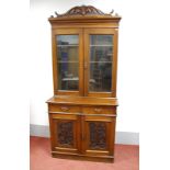 An Early XX Century Walnut Bookcase, with shaped pediment, twin glazed doors, internal shelves and