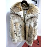 A Three-quarter Length Fur Coat, possibly lynx, with collar and hook fastening, 82cm long.