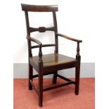 An Early XIX Century Elm Elbow Chair, with rectangular top rail, shaped arms and solid seat on