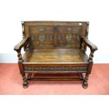 An Early XX Century Oak Monks Bench, with sliding top, carved back, hinged seat and carved frieze,