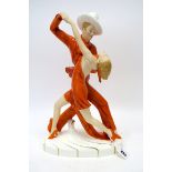 A Royal Dux Porcelain Figure Group 'Tango Dancers', in orange costumes, upon a gilt decorated oval