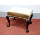 An XVIII Century Mahogany Stool, with rectangular upholstered top, gadrooned border, on carved
