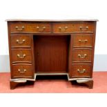 A XX Century Mahogany Serpentine Shaped Kneehole Desk, the crossbanded top with moulded edge over