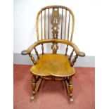 A MId XIX Century Yew Wood Rocking Chair, with a hooped back, pierced splat, pad arms, elm seat,