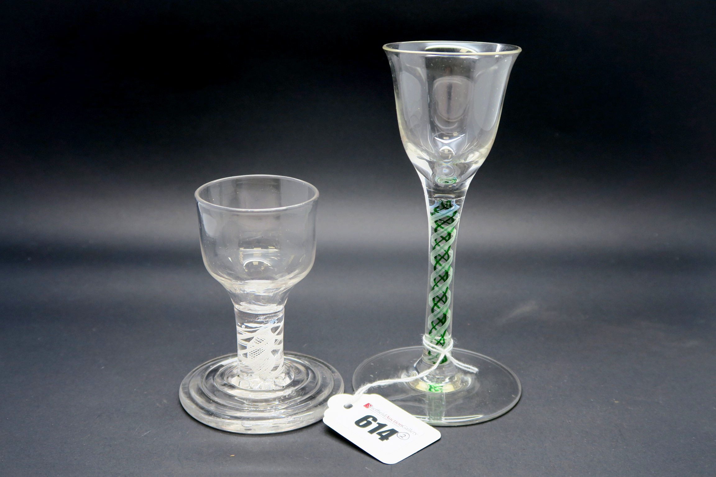 An XVIII Century Firing Glass, the plain ogee bowl raised on a white enamel twist stem and stepped