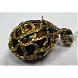 A 9ct Gold Pendant, of openwork egg shape, hinged housing a polished tigers eye egg inside, on