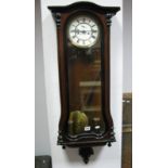 A XIX Century Walnut Vienna Wall Clock, with a white enamel dial, Roman numerals, glazed door,
