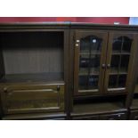 A XX Century Oak Effect Wall Unit, with twin glazed cupboard doors, open shelves, over panelled