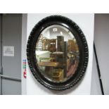 A XIX Century Oval Bevelled Wall Mirror, in tortoiseshell effect frame.