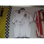 England Autographs - unverified. Fifteen signatures In black marker, on a white Umbro Home shirt.