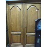 A Modern Pine Armoire, twin arched fielded panel doors over short drawers, reeded and canted ends,