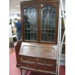 A 1920's Oak Bureau Bookcase, leaded glazed doors over fall front above two long drawers, on