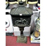 A Cast Iron Floor Standing Post Box, crown finial and fish scale top, moulded figural decoration and
