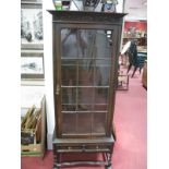 A 1920's Oak Display Cabinet, with carved frieze, glazed door, two internal shelves, single