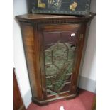 An XVIII Mahogany Corner Cupboard, dentil cornice over astragal glazed central door, fitted with