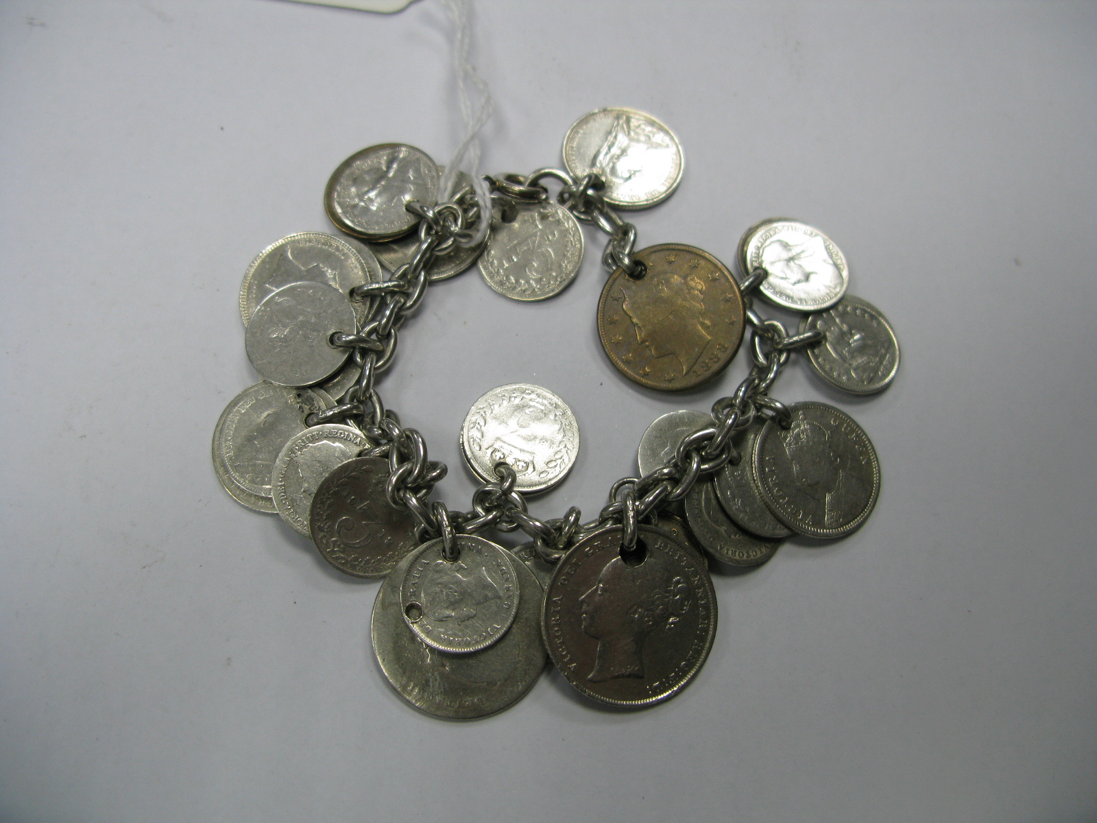 A Coin Charm Bracelet, suspending numerous assorted coins (drilled).