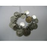 A Coin Charm Bracelet, suspending numerous assorted coins (drilled).