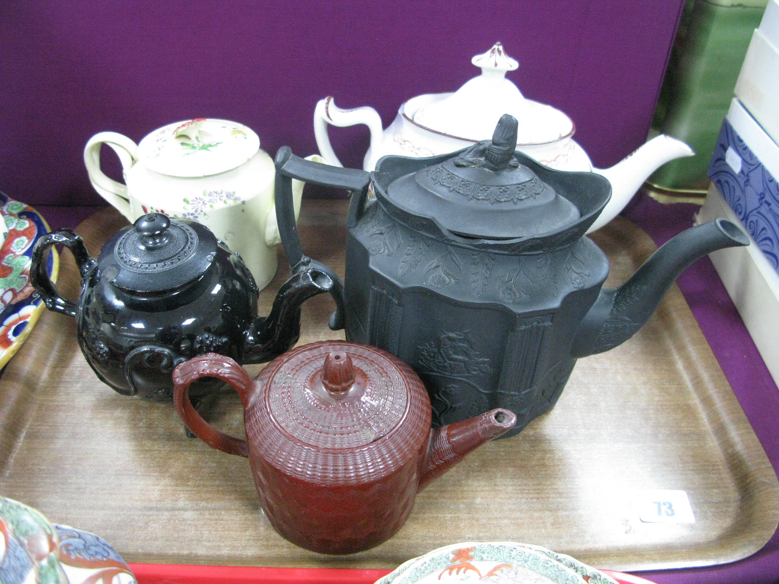 An XVIII Century Leeds Creamware Teapot, with intertwined handles (damages), black glazed Jackfield