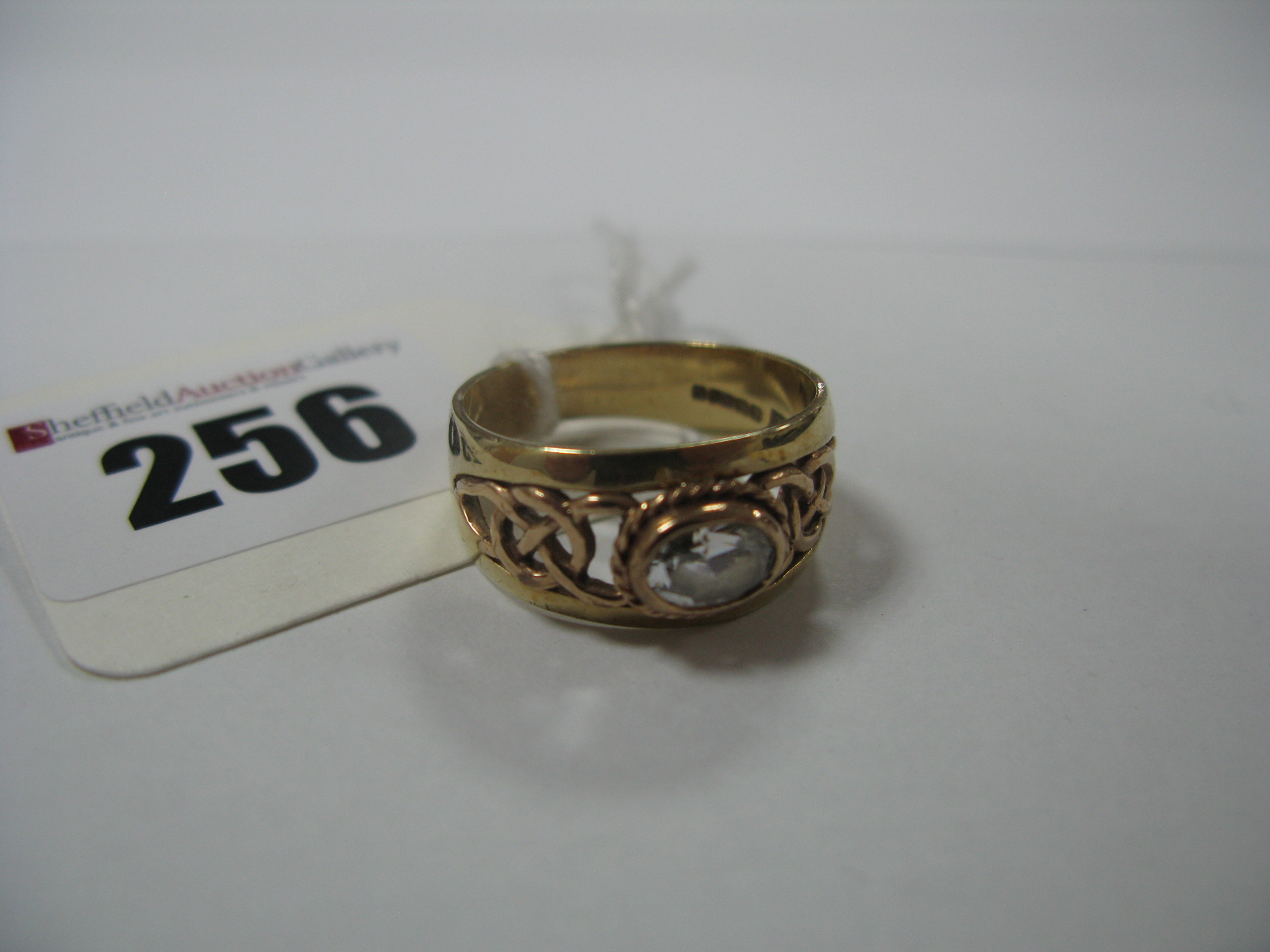 A 9ct Gold Single Stone Ring, of Celtic style, oval collet set to the centre.