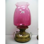 A XIX Century Brass Oil Lamp, with cranberry glass shade.