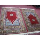 A Pair of Tassled Wool Rugs, with geometric designs on rust red ground with fruit border