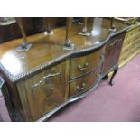 A 1920's Mahogany Bow Front Sideboard, with twin drawers, flanked by cupboard doors, below gadrooned