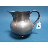 A Hallmarked Silver Jug, (makers mark indistinct) London 1894, of plain baluster form with reeded