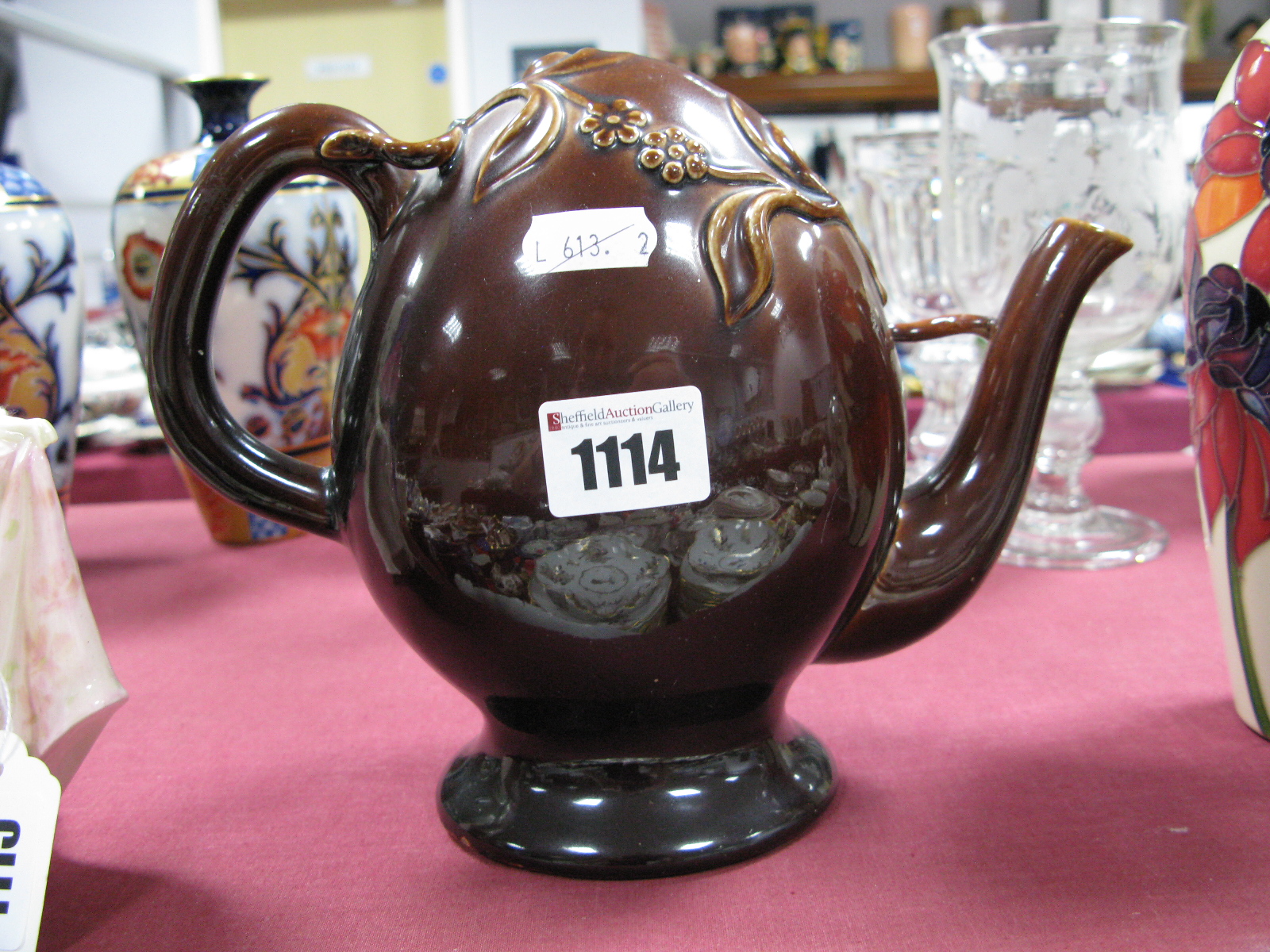 A Brameld Cadogan Teapot, the treacle glazed ovoid body applied with sprigs of flowers, unmarked,