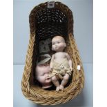 A Bisque Baby Doll, a composition dolls head and a dolls wicker crib.